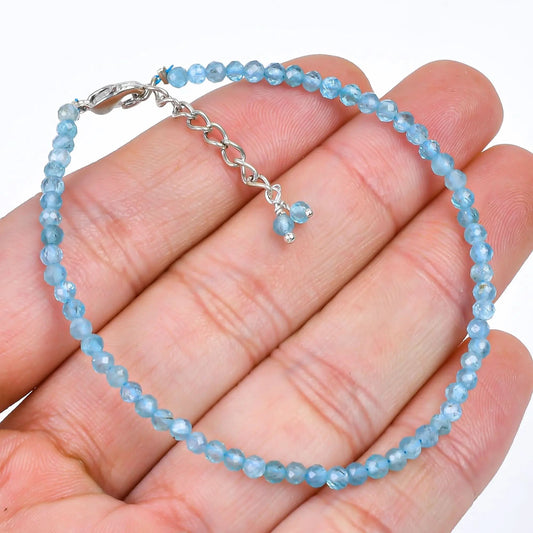 Natural blue apatite micro bead bracelet in 925 sterling silver on dark wood surface β front view
