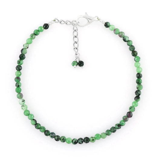 Natural ruby zoisite micro faceted bead bracelet on dark wood ā front view green with ruby inclusions