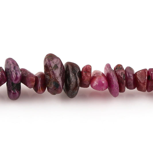 Close-up of red and brown beads on a white background