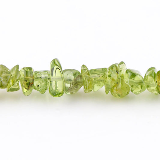 Close-up of green gemstone beads on a white background