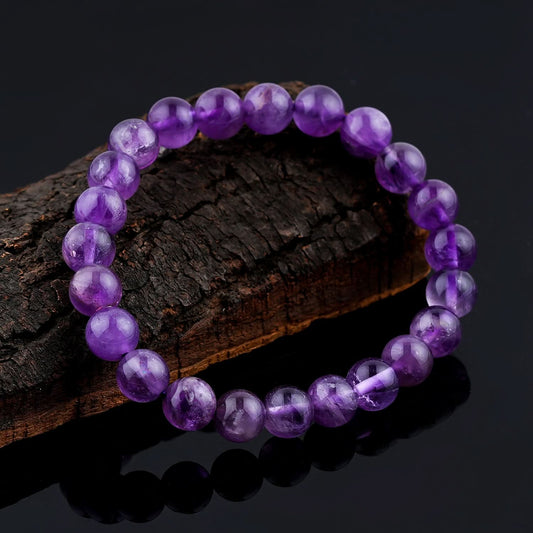 Amethyst Purple beaded bracelet on a dark wooden surface