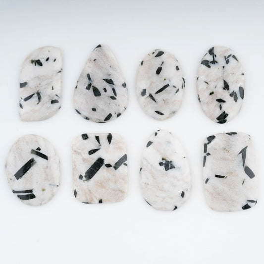 White cabochons surface with black tourmaline needle patterns