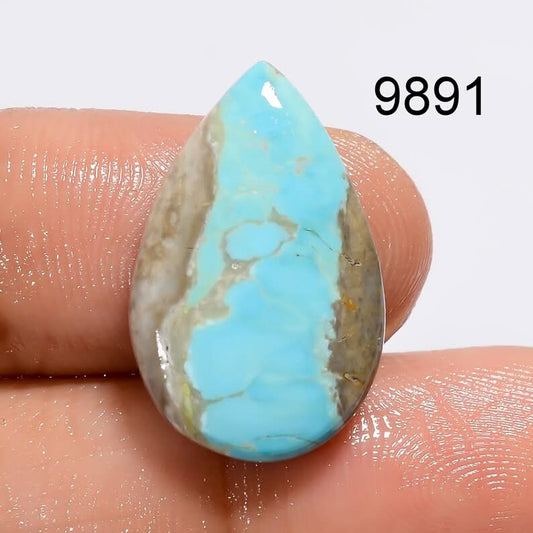 Teardrop-shaped turquoise stone held between fingers with a visible number '9891' in the corner.