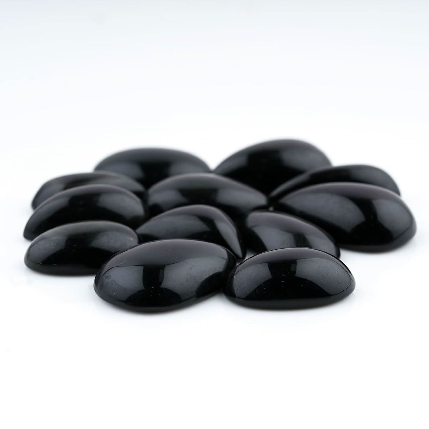 Black stones arranged in a circular pattern on a white background