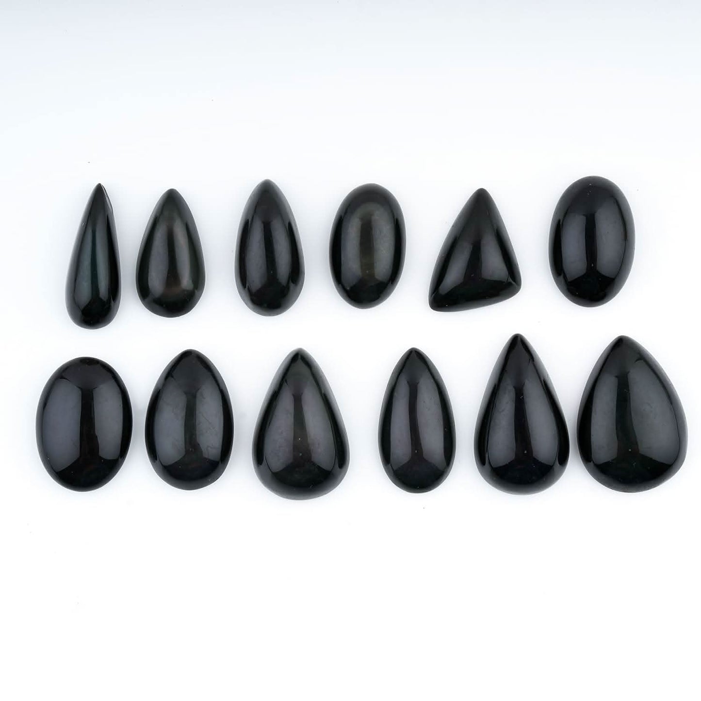 Set of black teardrop-shaped stones on a white background