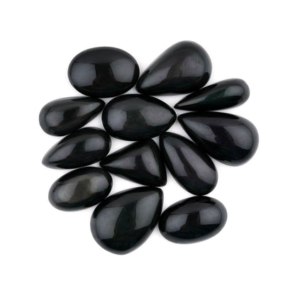 Black teardrop-shaped stones arranged in a circular pattern on a white background
