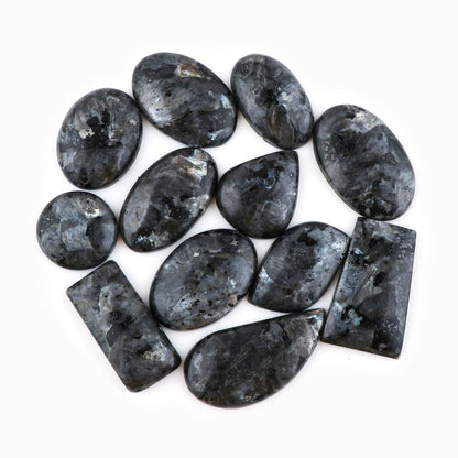 Natural larvikite gemstone cabochons pile – dark charcoal grey with silver blue feldspar flash