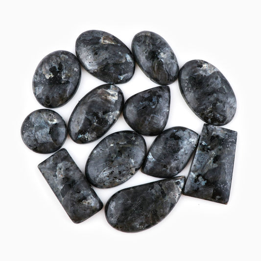 Natural larvikite gemstone cabochons pile – dark charcoal grey with silver blue feldspar flash
