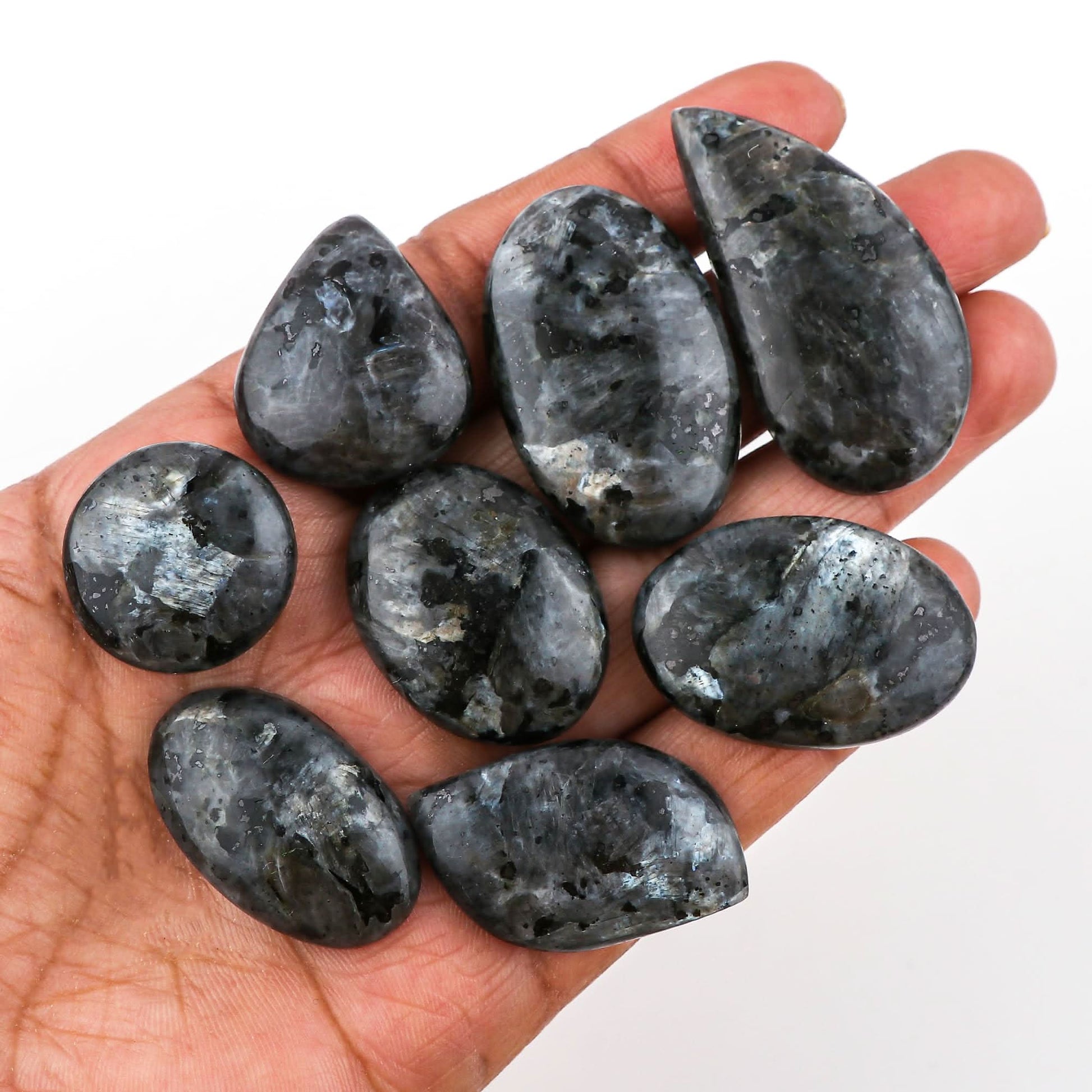 Natural larvikite wholesale cabochons held in hand – silver flash dark grey smooth polish