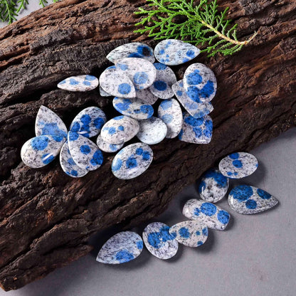 K2 stone cabochons held in hand for size reference
