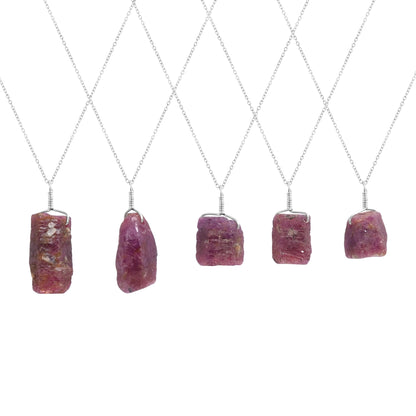Natural ruby raw stone pendant necklaces displayed vertically showing irregular bar shapes and silver-plated chains