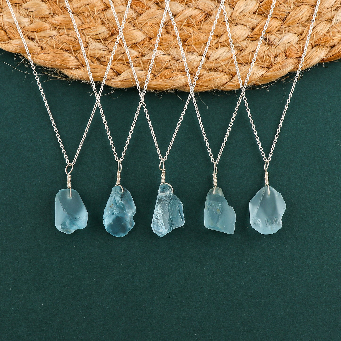 Sky blue topaz raw crystal pendant necklaces arranged in a row showing irregular gemstone shapes on silver-plated chains
