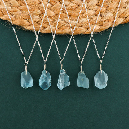 Sky blue topaz raw crystal pendant necklaces arranged in a row showing irregular gemstone shapes on silver-plated chains