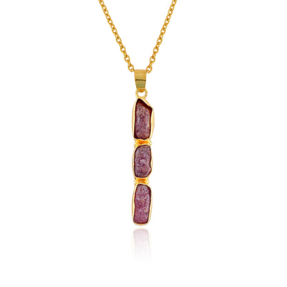 Raw ruby crystal pendant necklace in gold-plated bezel setting displayed on white background showing delicate pink gemstone