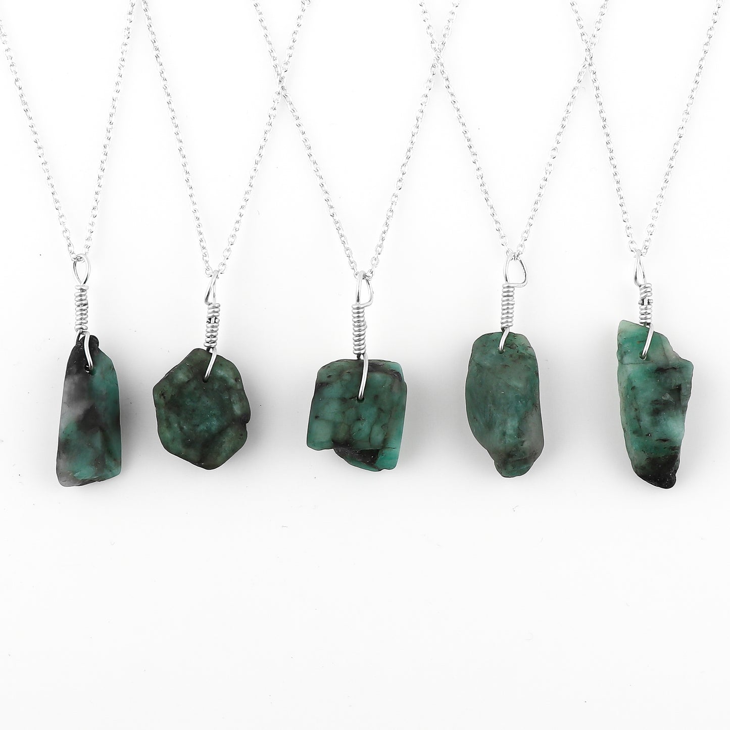 Five necklaces with green pendant stones on a white background