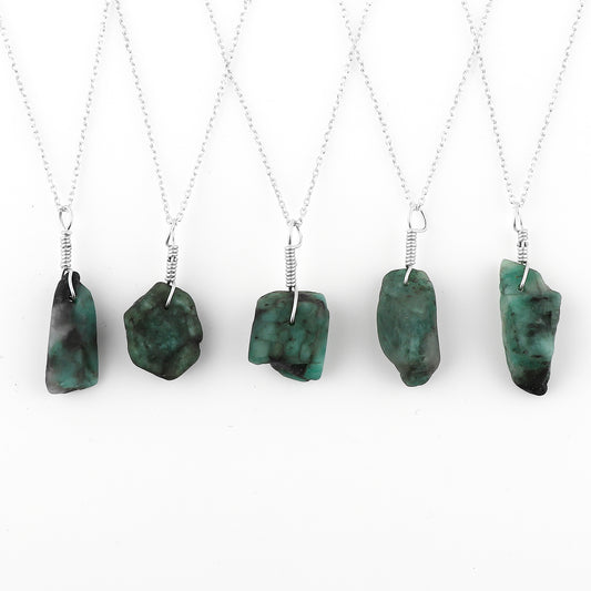 Five necklaces with green pendant stones on a white background
