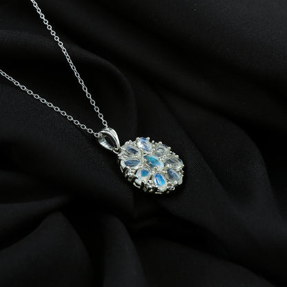 Silver necklace with a floral pendant on a black fabric background