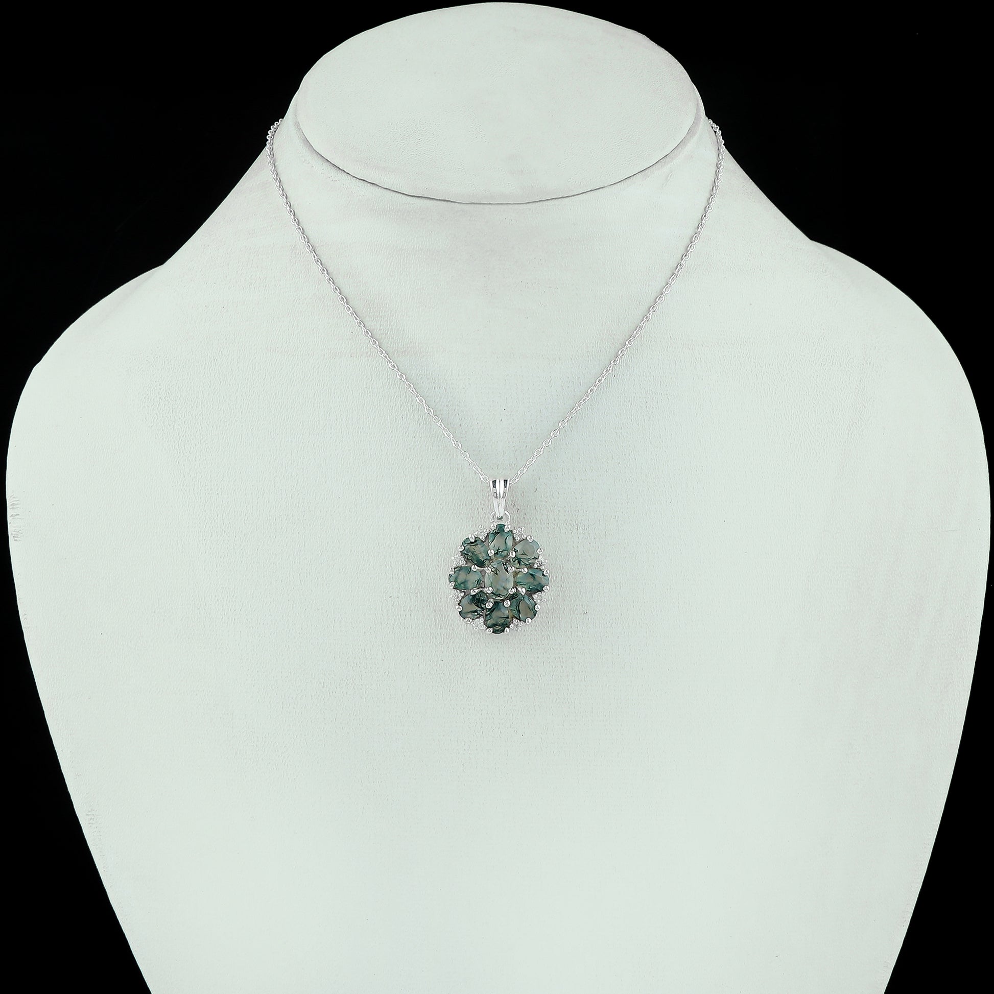 Green gemstone necklace on a mannequin with a black background