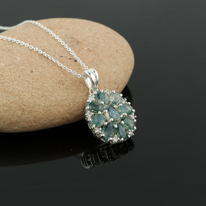 Silver necklace with a green gemstone pendant on a dark background