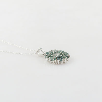 Silver necklace with a green gemstone pendant on a light gray background