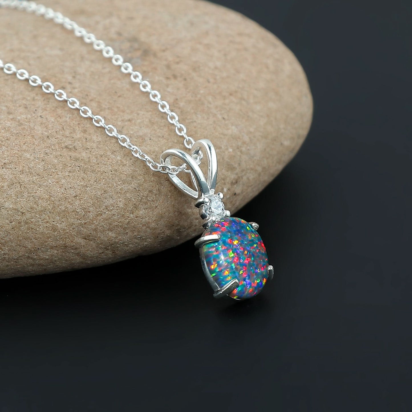 Opal pendant necklace on a stone surface