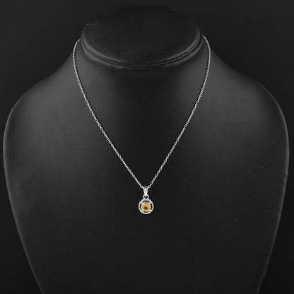 Silver necklace with a yellow gemstone pendant on a black mannequin.