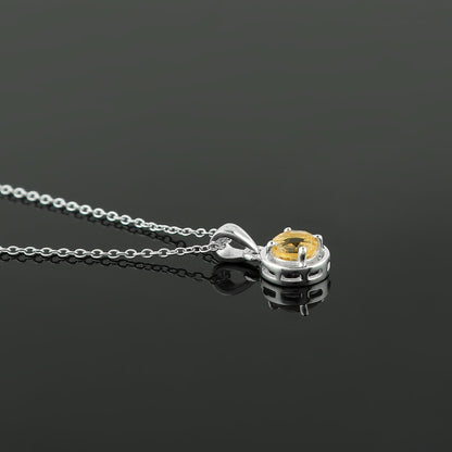 Silver necklace with a yellow gemstone pendant on a black background