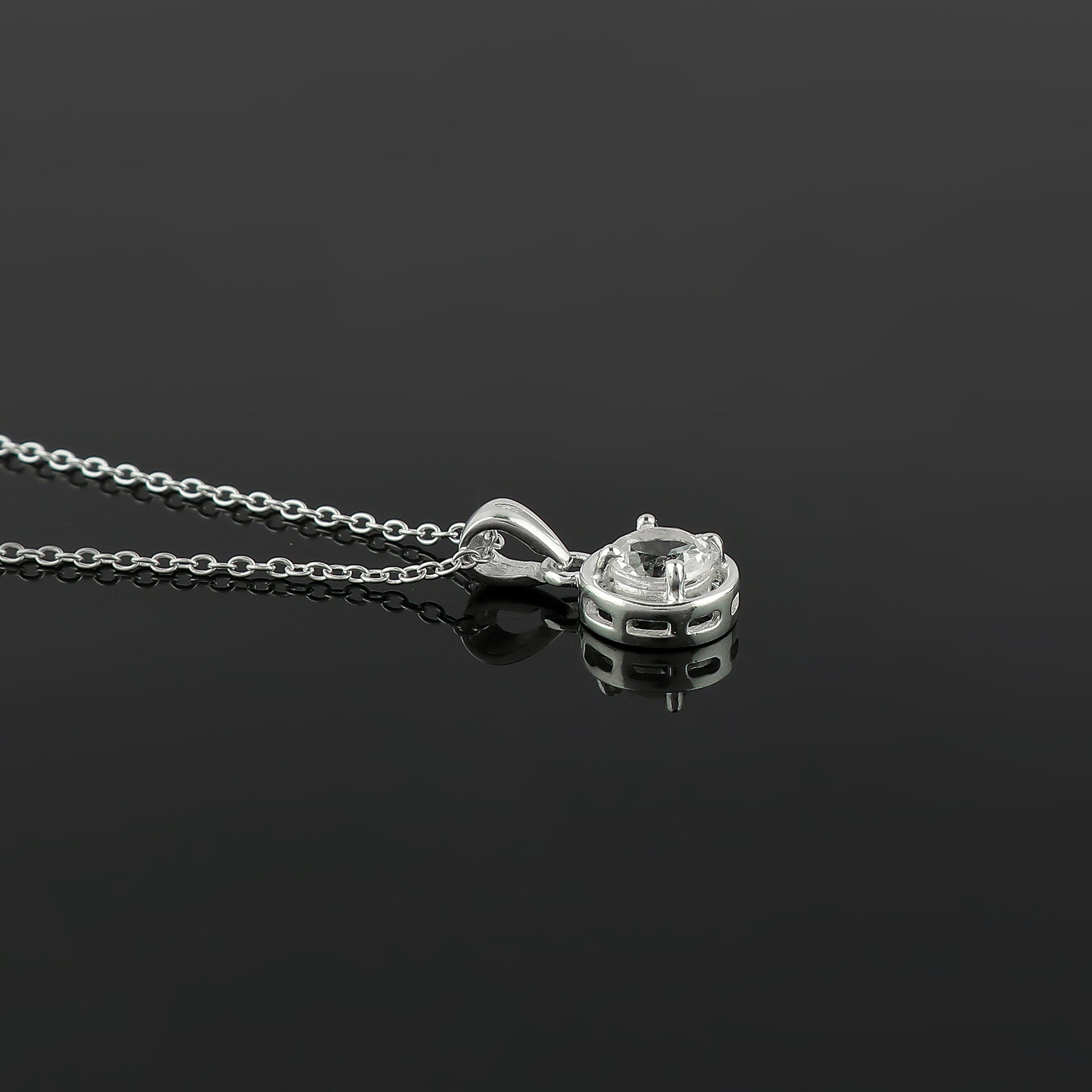Silver necklace with a pendant on a black background