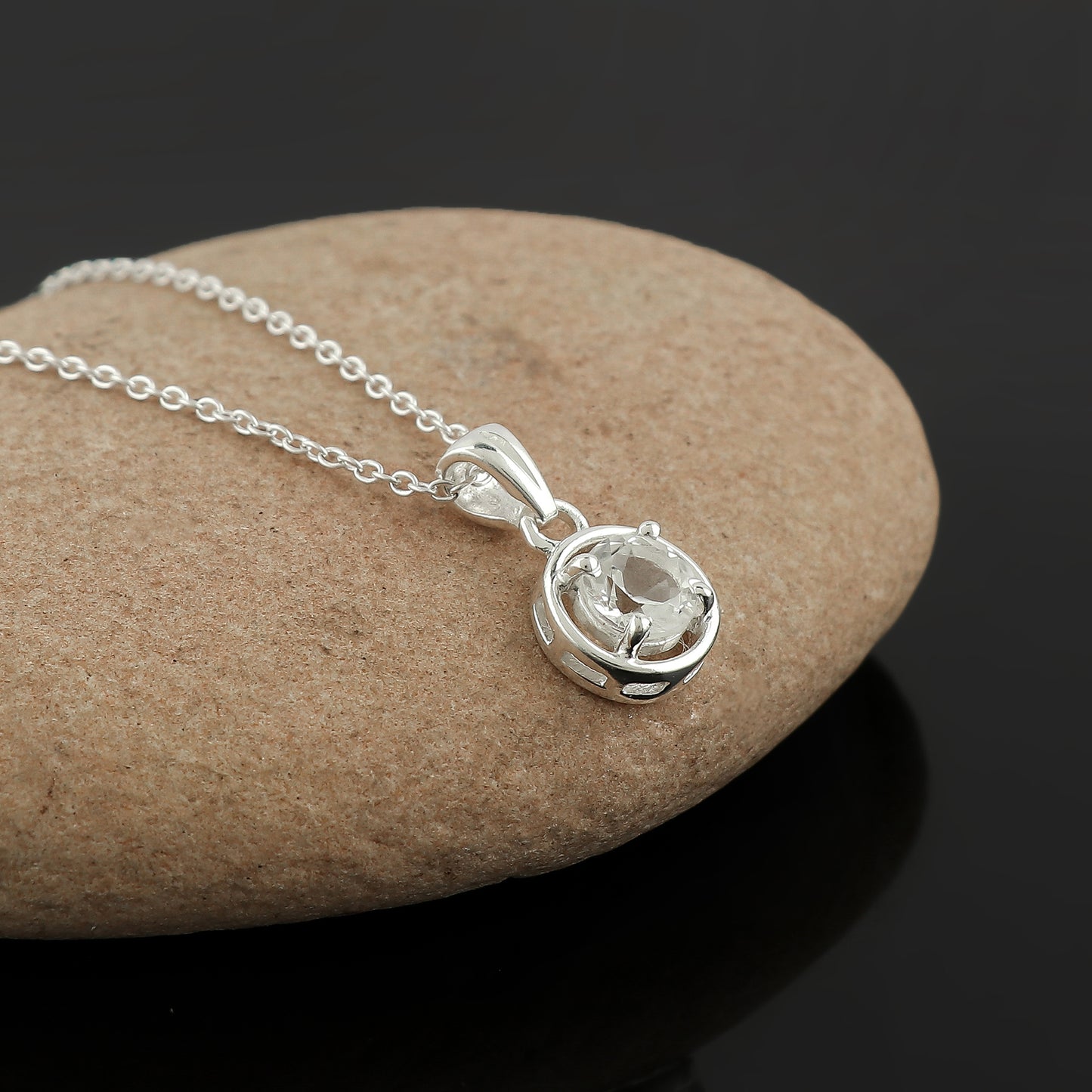 Silver necklace with a pendant on a stone surface