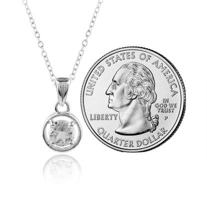 Silver necklace with a round pendant next to a U.S. quarter dollar coin on a white background