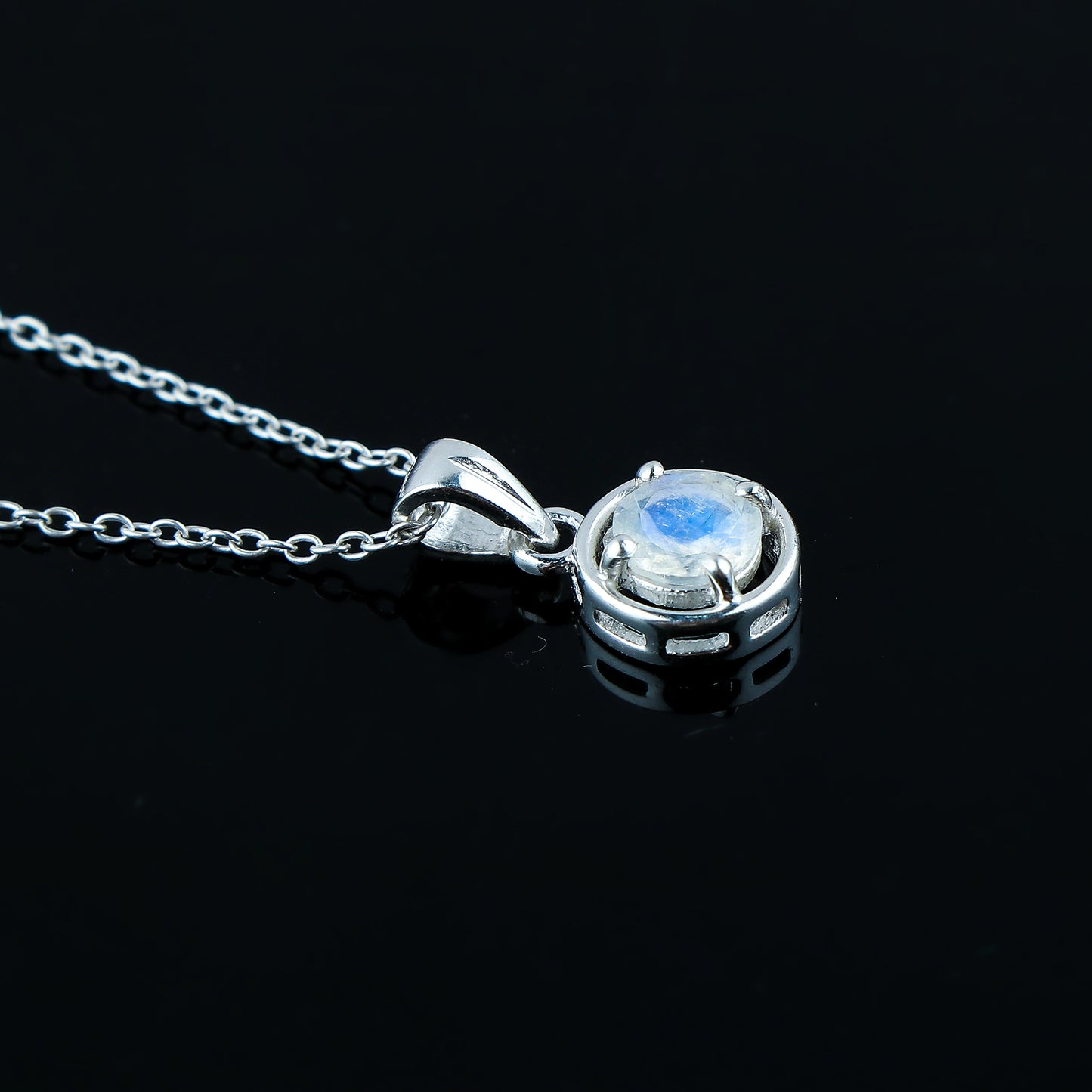 Silver pendant with a central gemstone on a black background