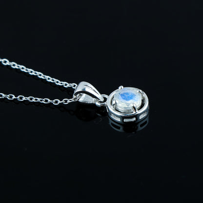 Silver pendant with a central gemstone on a black background