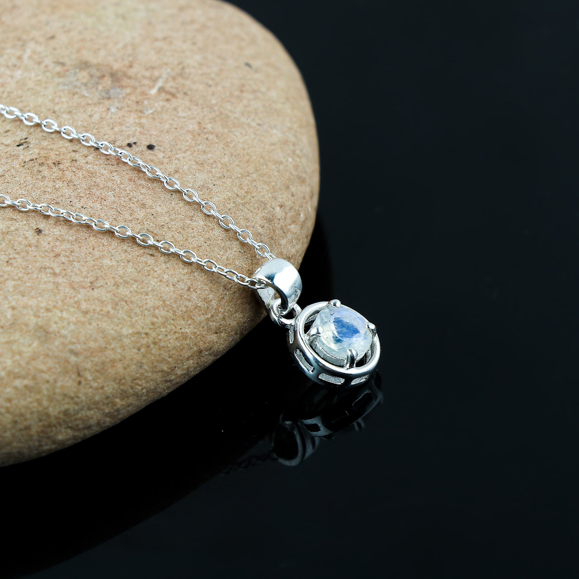 Silver necklace with a pendant on a stone surface