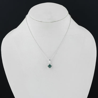 Silver necklace with a green pendant on a mannequin against a black background