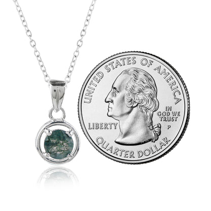 Silver pendant with green gemstone next to a U.S. quarter dollar coin on a white background