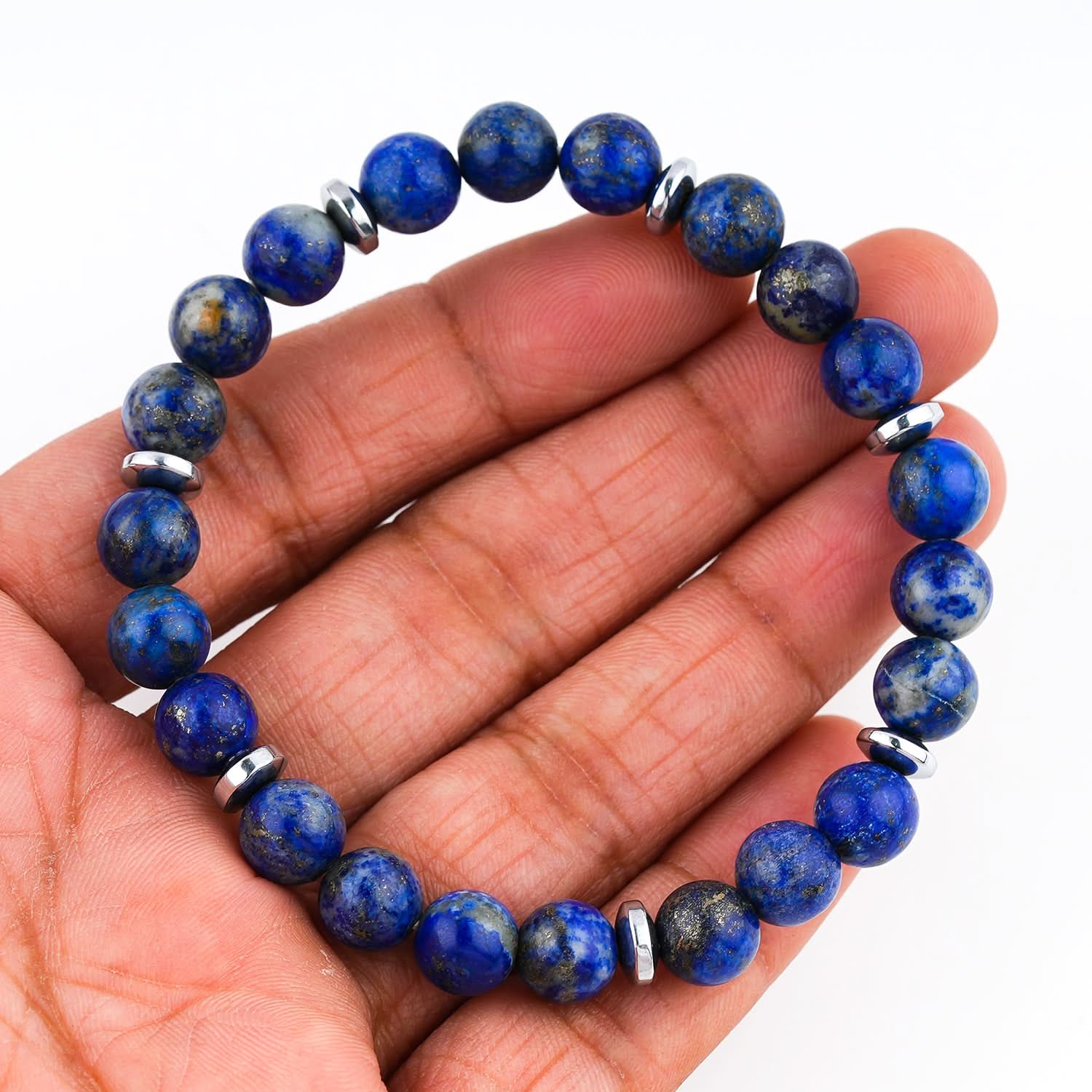 Lapis Lazuli Blue beaded bracelet on a hand with a white background