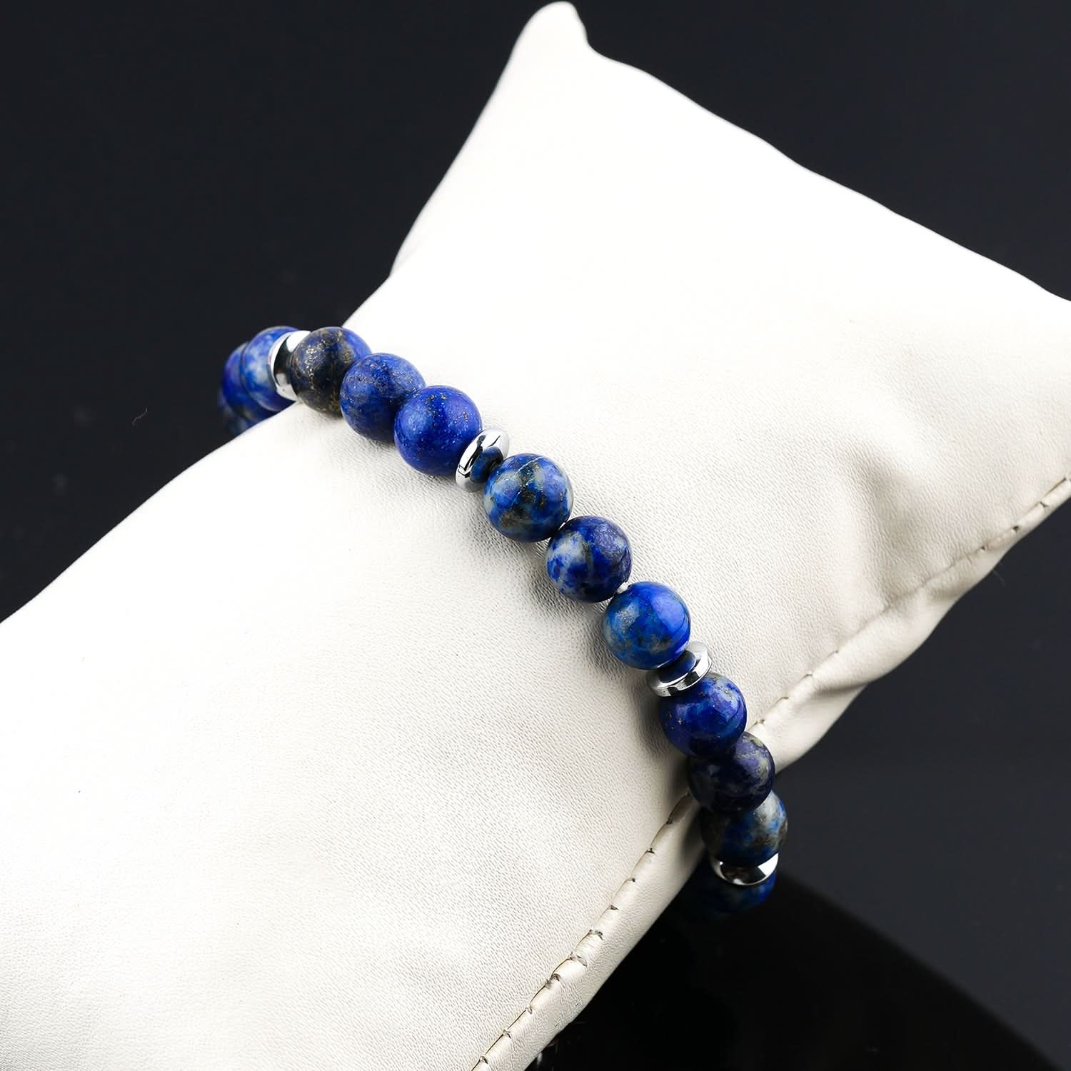 Lapis Lazuli Blue beaded bracelet on a white cushion with a black background