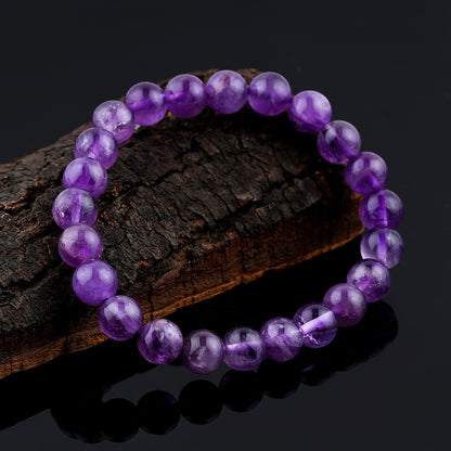 Amethyst  Purple beaded bracelet on a dark wooden surface