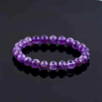 Purple beaded bracelet on a black reflective surface