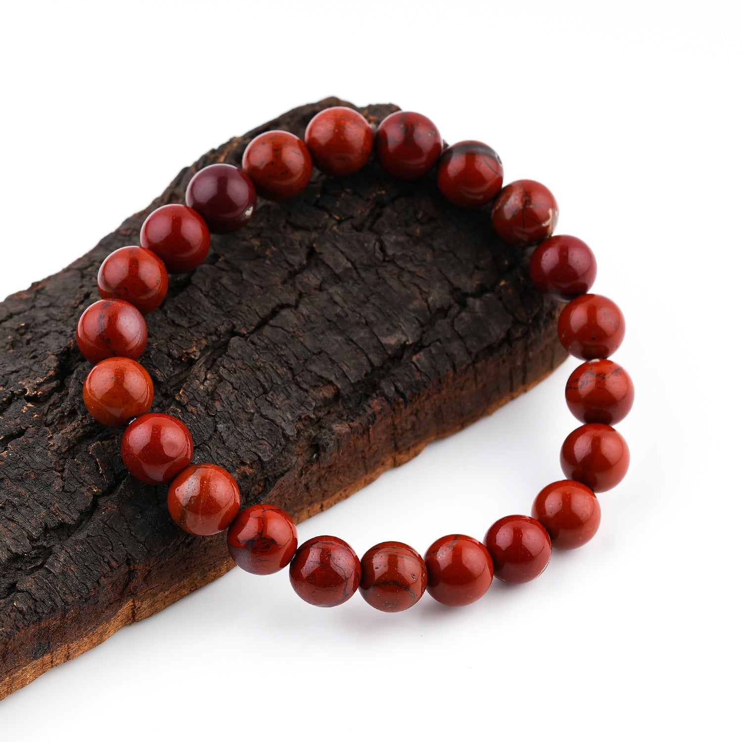 Red Jasper Beaded Bracelet on a wooden surface with a white background