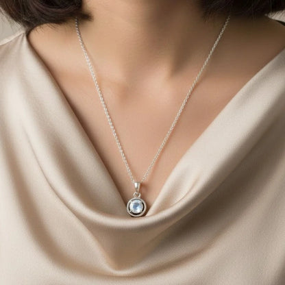 Transparent polished moonstone pendant with subtle glow on a model's neck
