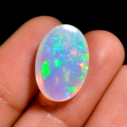 Oval-shaped 5.50 carat white Ethiopian opal cabochon with vivid play-of-fire. 
