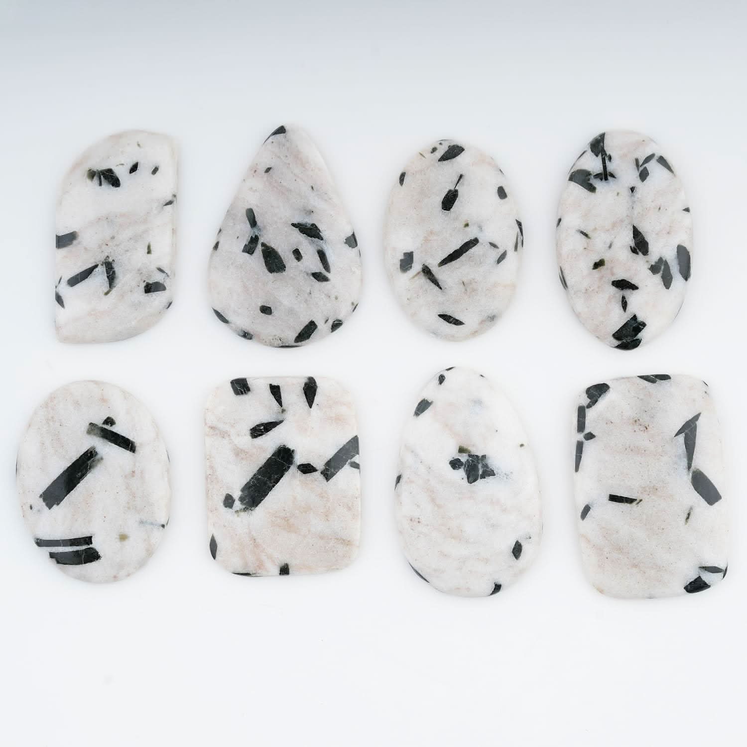 White cabochons surface with black tourmaline needle patterns
