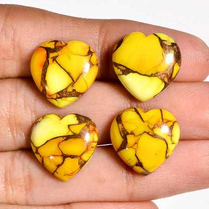 Yellow copper turquoise heart gems for jewelry making held on a hand to show the 15 MM size