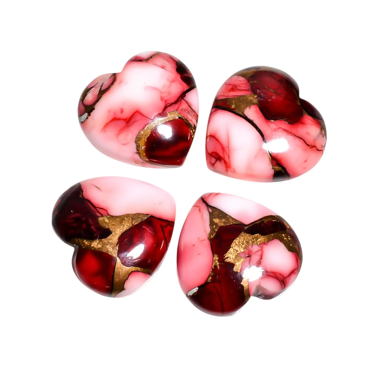 Four deep red Mohave turquoise heart cabochons with pink marbling and gold copper matrix on a white background