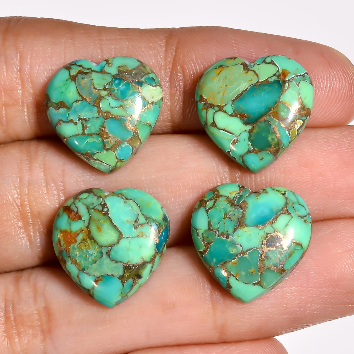 Green Spider Turquoise heart cabochon arranged in a designer's flat lay, shown alongside tools and findings used in handmade jewelry work