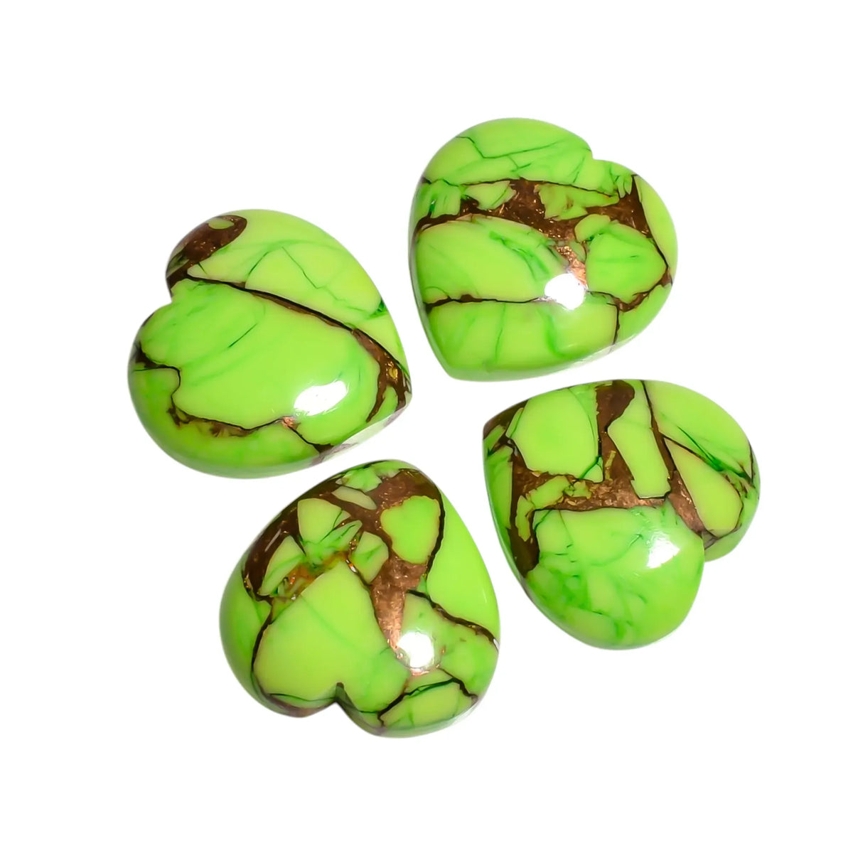 Four light green Mohave turquoise stones, loose heart cabochons with copper veins on a white background