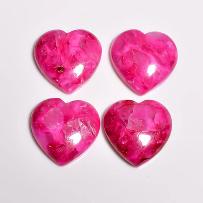Polished pink turquoise stone heart cabochons showing clear crystal-like patches and pale veining, top view