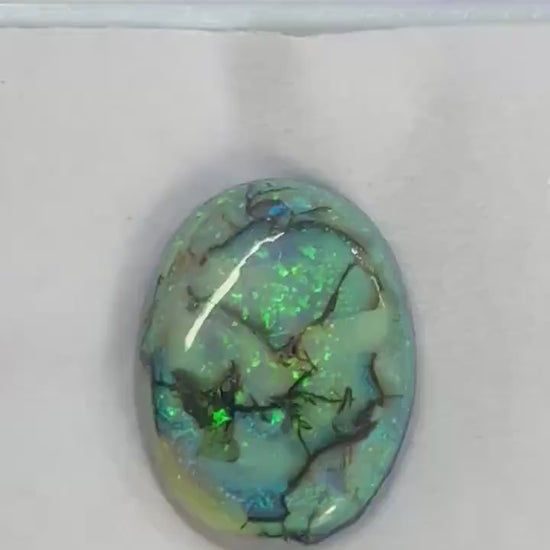 Angled view of lab created Sterling Opal cabochon, synthetic opal gemstone...