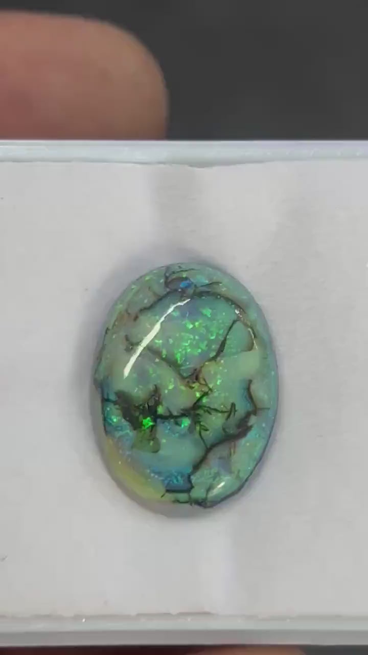 Angled view of lab created Sterling Opal cabochon, synthetic opal gemstone...